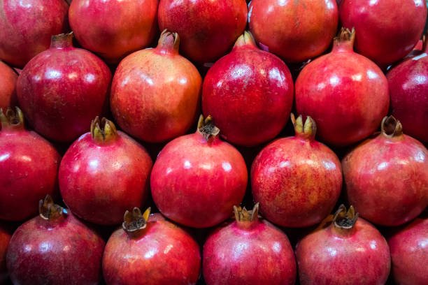 Group of pomegranates. Pomegranate closeup, background. ripe fruits neatly laid out on the counter in the store